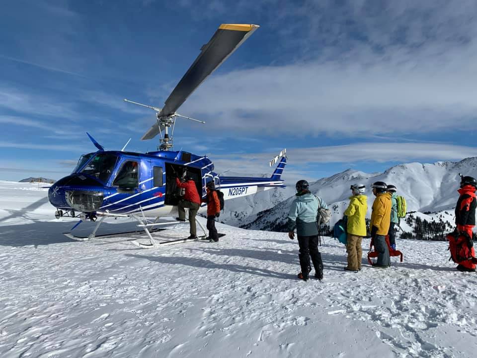 A group of people loading onto a helicopter to go snowboarding
